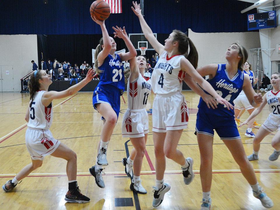 Heritage's Madison Moretti (21) takes a shot over Grace Academy's Jillian Harper (4) in the first half of a Mason Dixon Christian Conference girls basketball game on Feb. 4 at Grace.