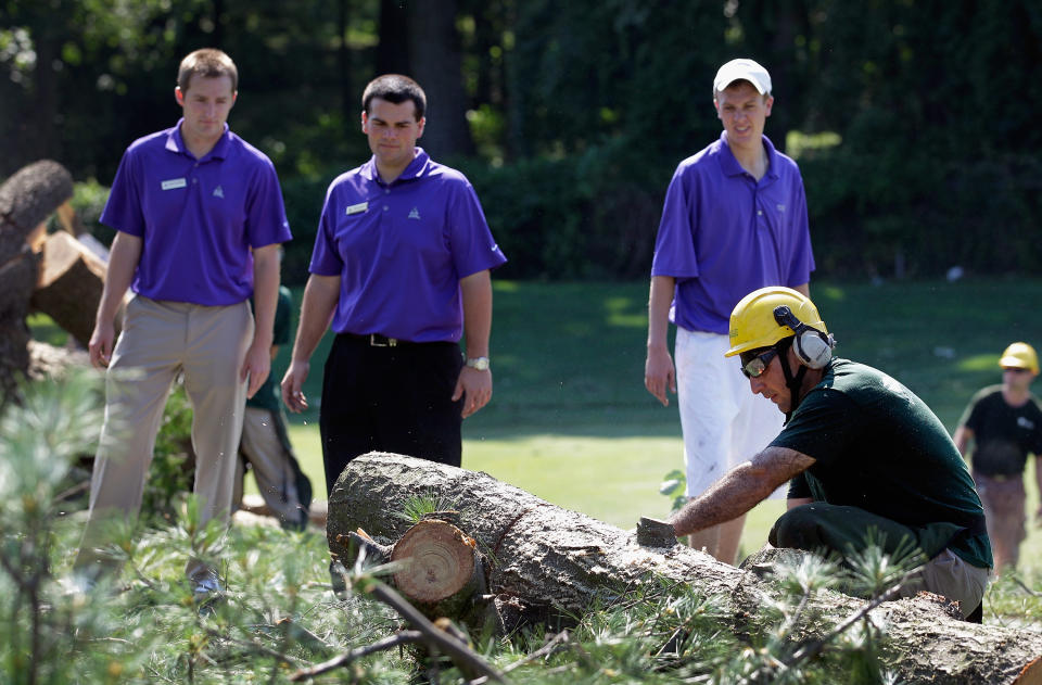 Workers cut up a tree along the 14th fairway from overnight storm damage that delayed the start of Round Three of the AT&T National at Congressional Country Club on June 30, 2012 in Bethesda, Maryland. (Photo by Rob Carr/Getty Images)