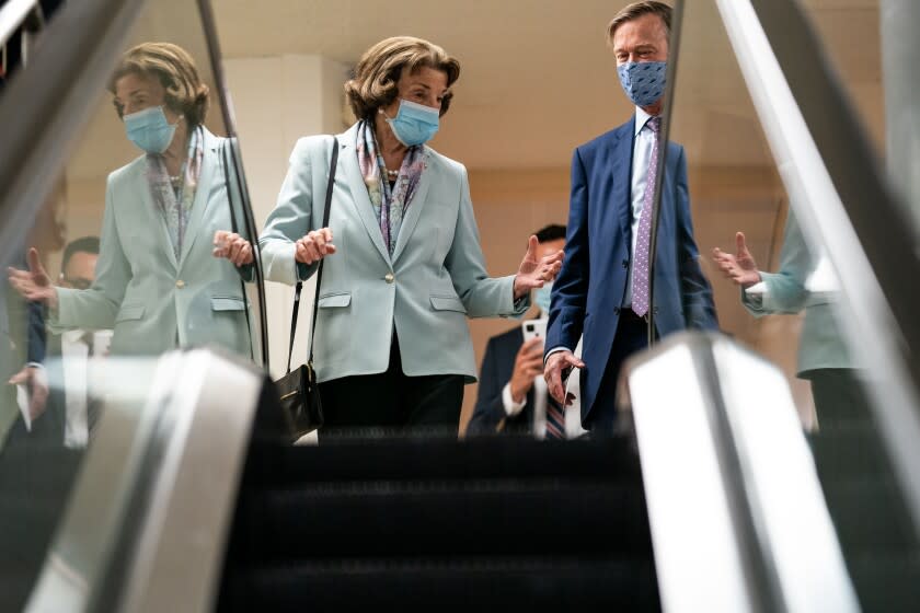 WASHINGTON, DC - AUGUST 03: Sen. Dianne Feinstein (D-CA) speaks with Sen. John Hickenlooper (D-CO) as they make their way through the Senate Subway on Capitol Hill on Tuesday, Aug. 3, 2021 in Washington, DC. (Kent Nishimura / Los Angeles Times)