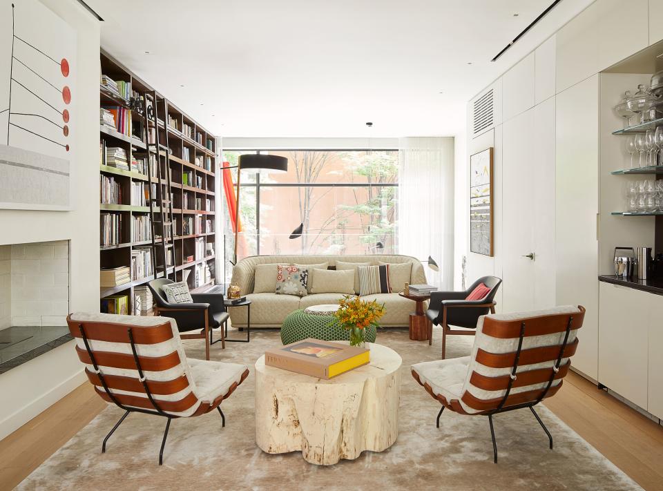 The adults-only formal living room, with Jonas Wood’s Square Red Dot and a canvas by Belgian artist Harold Ancart, is where the couple hosts cocktails when they entertain. Years before they moved in, Verhoeven had hunted down the pair of Carlo Hauner chairs on 1stdibs, “before 1stdibs was really a thing,” she says. “I fell in love with them, especially the back view.” Curtis contributed an oft-used, functional, and fun green pouf from Moroso (“a stretch for them aesthetically!”) to the space overlooking the downstairs living room.