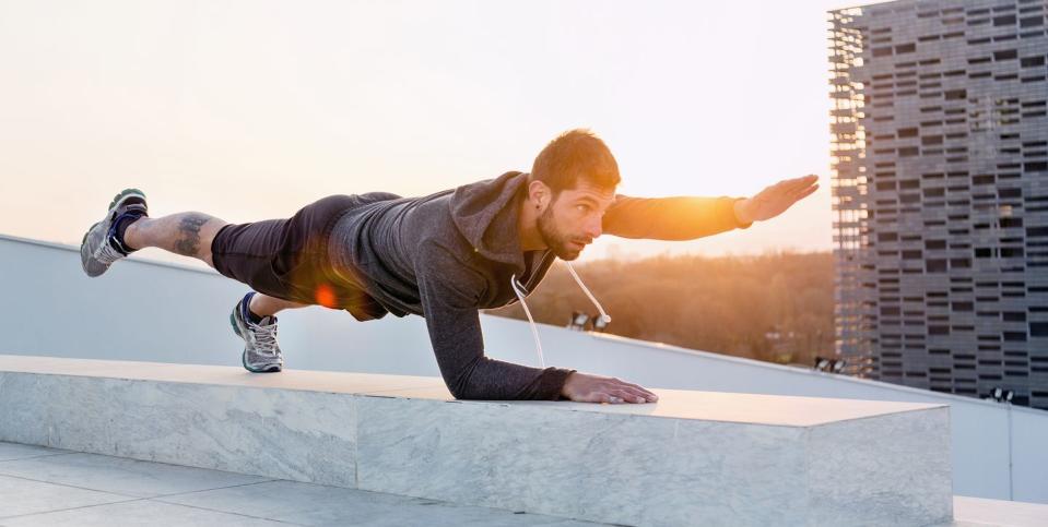 mid adult man exercising outdoors, in yoga position