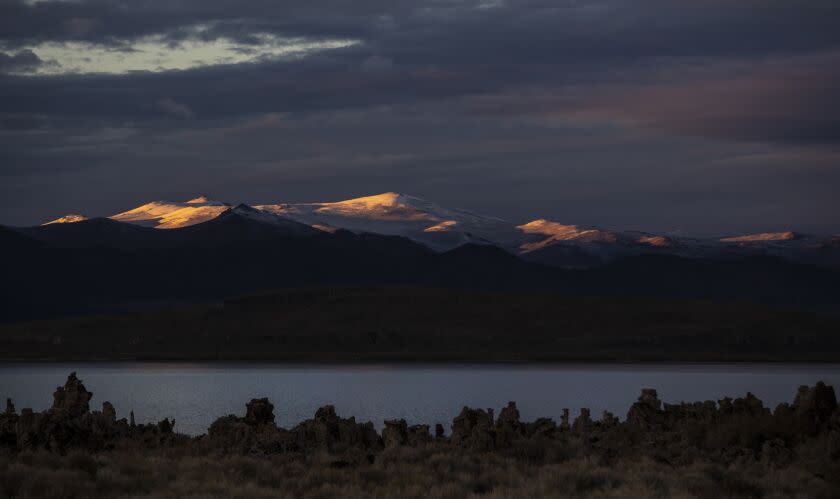 LEE VINING, CA - October 26 2021: Snowcapped mountains north of Mono Lake are aglow with the last rays of the setting sun on Tuesday, Oct. 26, 2021 in Lee Vining, CA. Regulatory officials hope to coax the LADWP to reduce diversion of water from Mono Lake to help mitigate air pollution. (Brian van der Brug / Los Angeles Times)