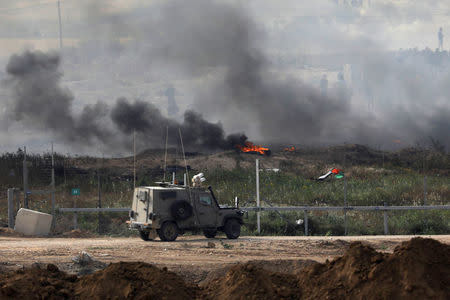 An Israeli military vehicle is seen next to the border fence on the Israeli side of the Israel-Gaza border, as Palestinians protest on the Gaza side of the border, Israel April 5, 2018. REUTERS/Amir Cohen