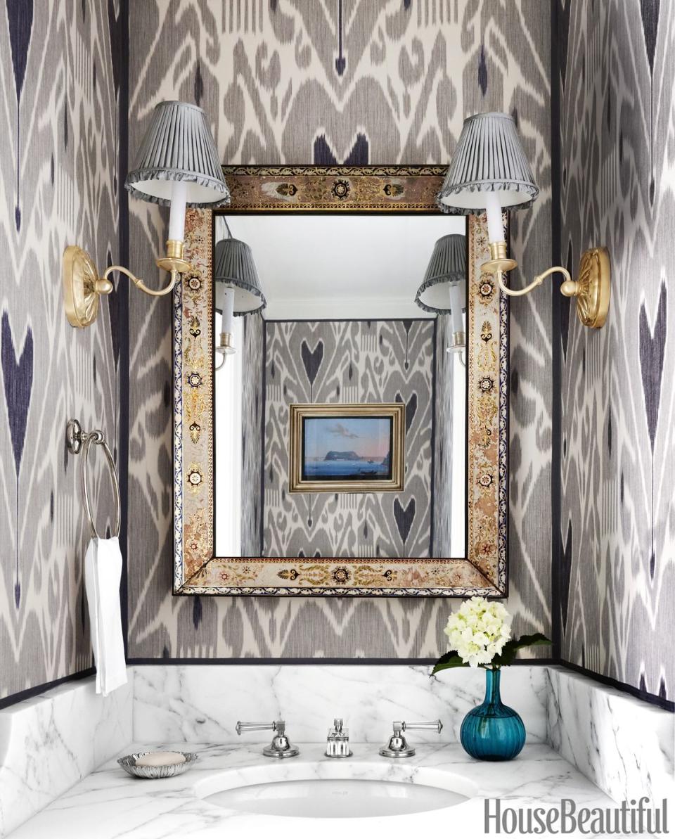 <p>When used in such a small space, this silk ikat wallcovering's large-scale print seems energizing rather than overwhelming. The 1820s French mirror's reverse-painted frame keeps the graphic patterns coming.</p>