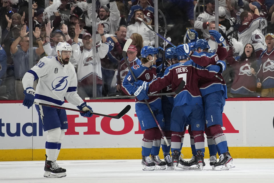 Colorado Avalanche players celebrate a goal by Valeri Nichushkin as Tampa Bay Lightning left wing Nicholas Paul, left, skates past during the first period in Game 2 of the NHL hockey Stanley Cup Final on Saturday, June 18, 2022, in Denver. (AP Photo/John Locher)