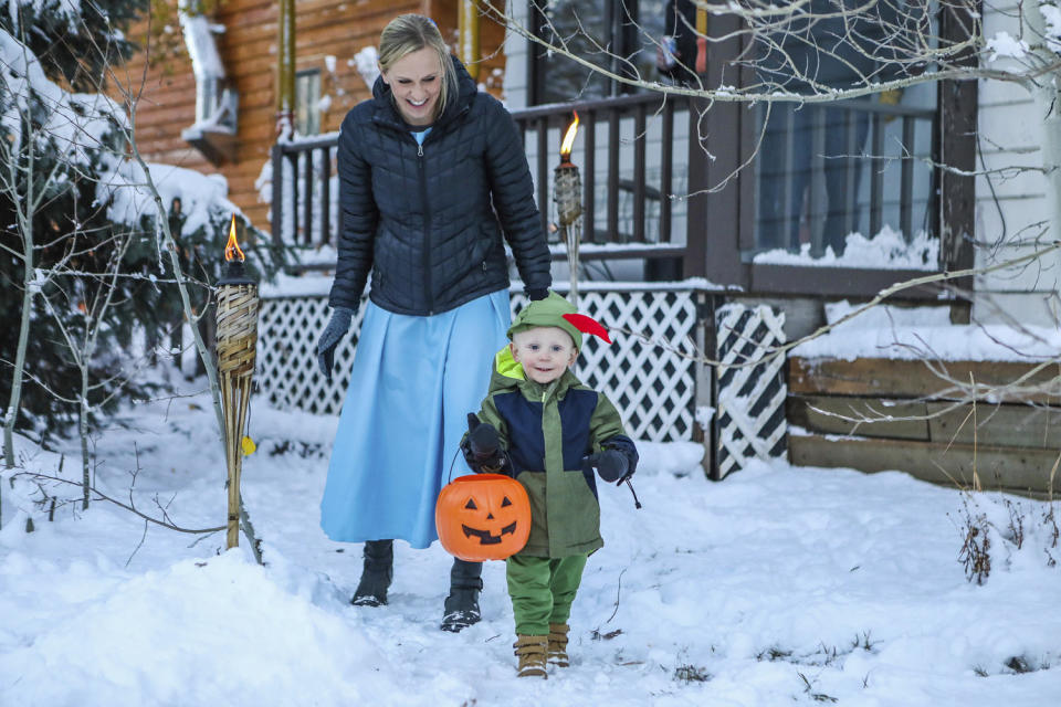 Katie Brandl follows Duke, 2, on the hunt for treats during a trick-or-treat event Monday, Oct. 30, 203, in Minturn, Colo.  (Chris Dillmann / Vail Daily via AP)