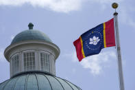 The magnolia centered banner chosen Wednesday, Sept. 2, 2020 by the Mississippi State Flag Commission flies outside the Old State Capitol Museum in downtown Jackson, Miss. The nine member committee voted to recommend a design with the state flower. That design will go on the November ballot for voters consideration and if approved, it will become the new state flag. (AP Photo/Rogelio V. Solis)