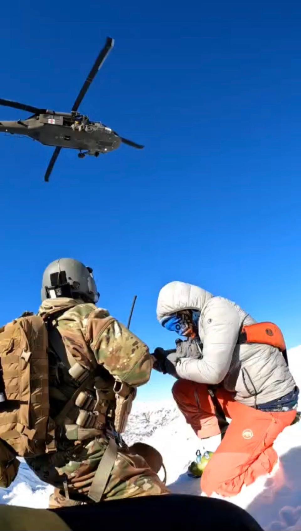 Staff Sgt. Matthew Medeiros, left, a RI Army National Guard paramedic, prepares to lift an avalanche survivor to a Black Hawk helicopter via an aerial hoist during a Jan. 22 rescue mission in Albania.