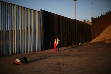 Tourists take pictures next to the fence separating Mexico and the United States, in Tijuana, Mexico. REUTERS/Edgard Garrido