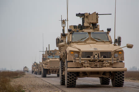 A Coalition convoy of U.S. led international coalition against the Islamic State of Iraq and the Levant (ISIL) stops to test fire their M2 machine guns and MK19 grenade launcher in the Middle Euphrates River Valley in the Deir ez-Zor province, Syria, November 22, 2018. Courtesy Matthew Crane/U.S. Army/Handout via REUTERS/Files