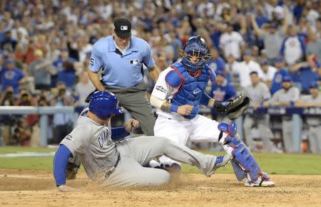 Oct 19, 2016; Los Angeles, CA, USA; Chicago Cubs first baseman Anthony Rizzo (44) scores a run past Los Angeles Dodgers catcher Yasmani Grandal (9) in the 6th inning during game four of the 2016 NLCS playoff baseball series at Dodger Stadium. Mandatory Credit: Richard Mackson-USA TODAY Sports