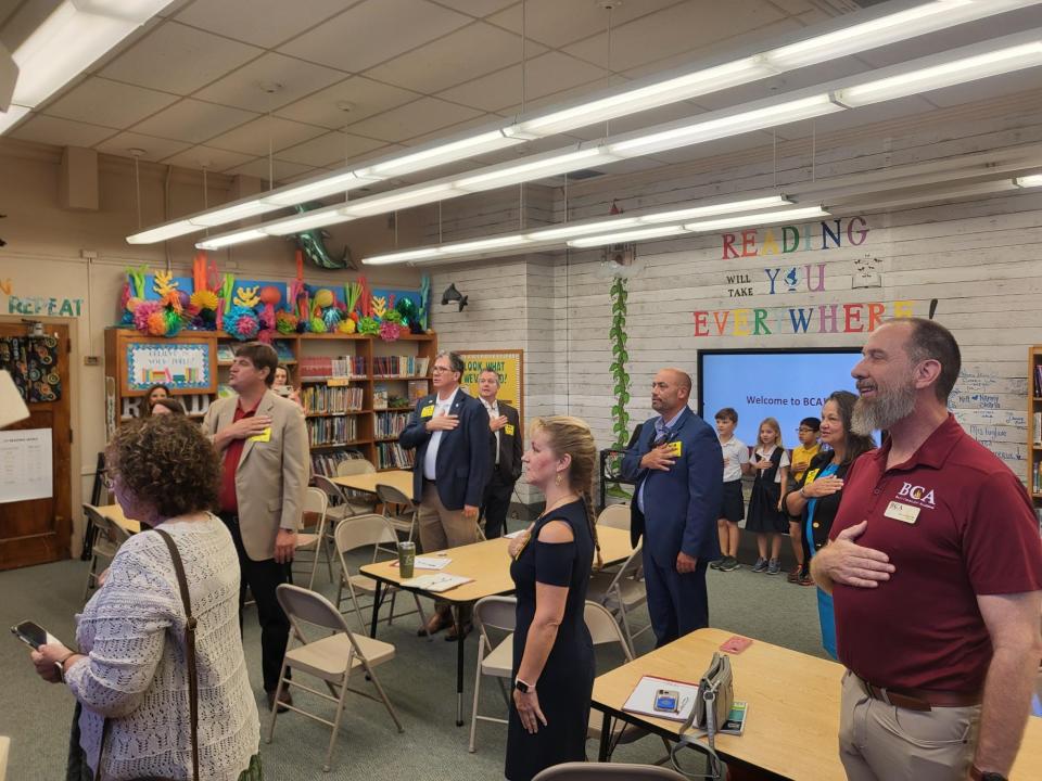 Lawmakers and school officials recite the pledge of allegiance led by school children, Wednesday, September 6, at Bayou Community Academy.