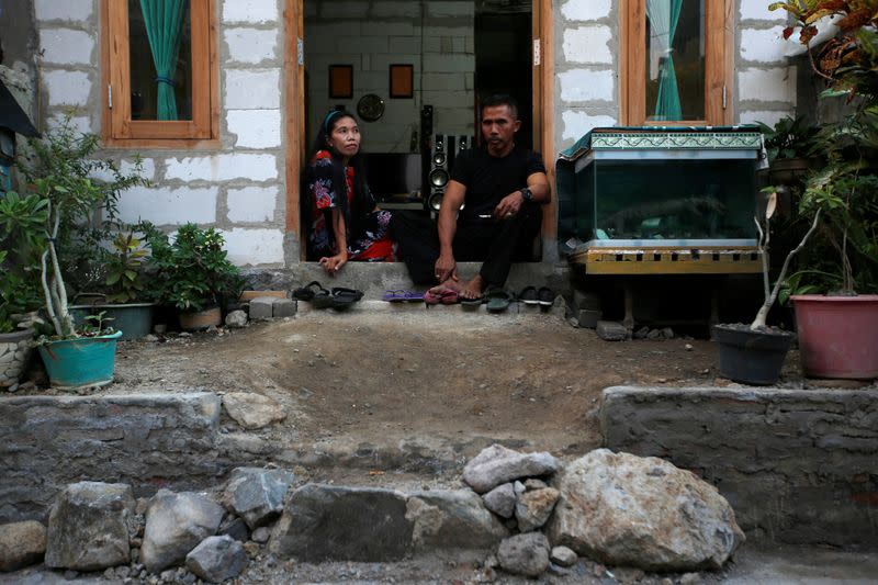 Solihatun and husband Nasroh sit in their newly-raised house as they pose for pictures at Tambakrejo, a village affected by land subsidence and rising sea level, in Semarang