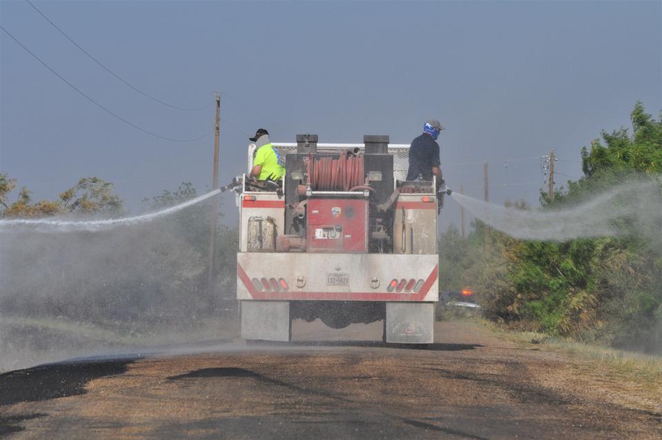 Crew members on the Buffalo Gap Volunteer Fire Department Brush Truck 1 on Friday do mop-up work along County Road 282 that had been scorched by the Mesquite Heat Fire.
