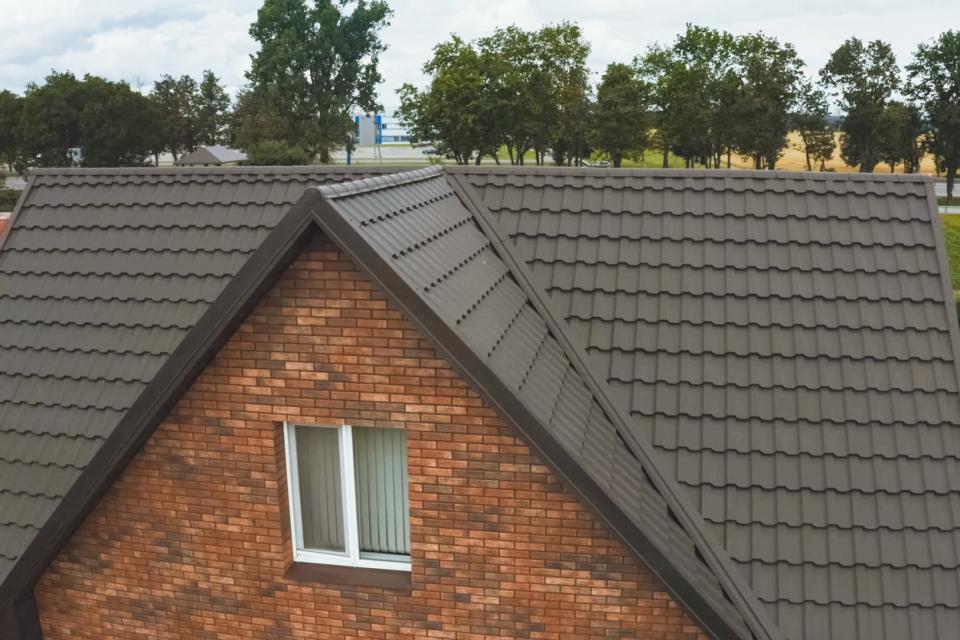 Modern roof made of metal. House with a brown metal roof.