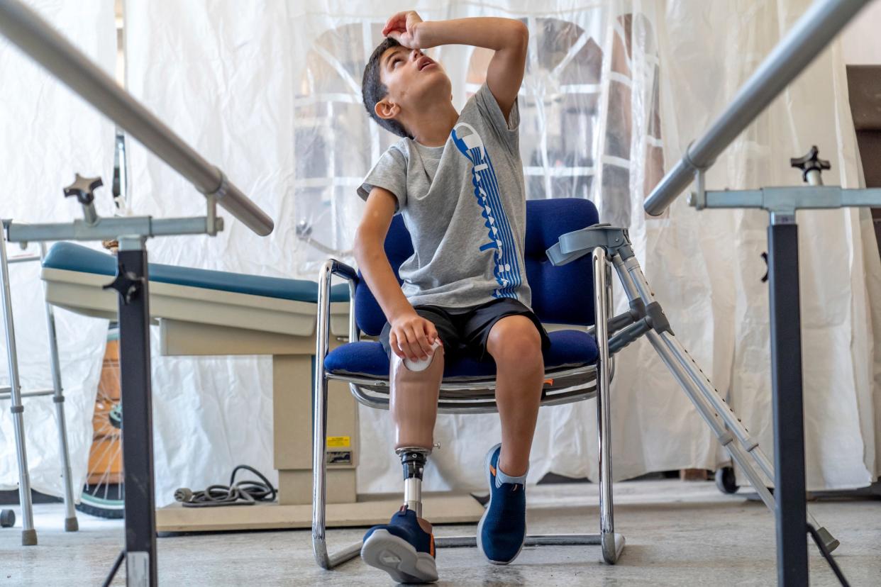 Saleh Humaid, 8, of Gaza, takes a seat after practicing walking with his prosthetic leg at Anew Life Prosthetics and Orthotics in Detroit on Thursday, July 27, 2023. Humaid's leg was bombarded with the shrapnel from an exploding car he and his dad happened to be passing in the road as it was targeted for a drone strike. The damage to his nerves was too severe to repair and surgeons in the Gaza Strip could not save his limb.