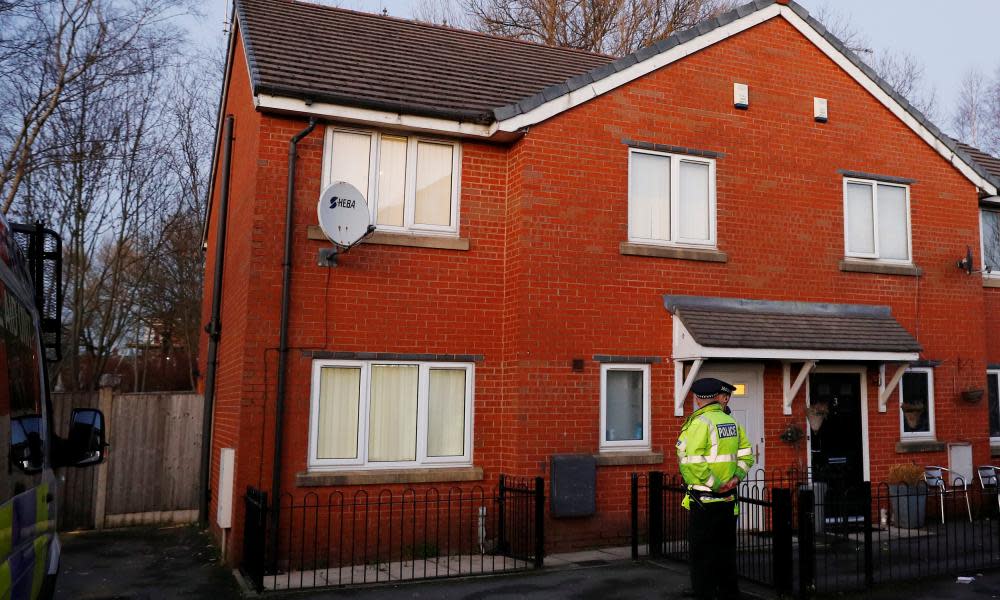 Police officers stand outside a house in Cheetham Hill, Manchester