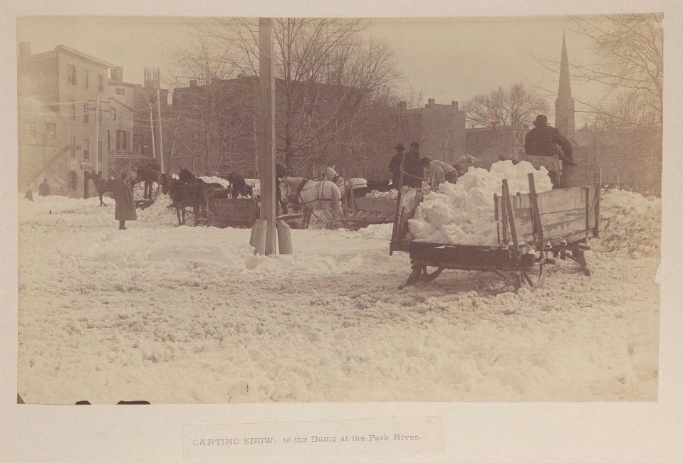 St. John's Episcopal church and the First Baptist church can be seen in the background as snow shovelers work to clear the roads in Hartford, Conn. 