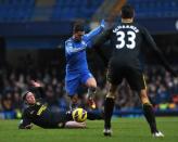 Chelsea midfielder Eden Hazard (C) jumps a sliding tackle from Wigan Athletic defender Ronnie Stam at Stamford Bridge, on February 9, 2013. Chelsea won 4-1 to ease some of the pressure on interim manager Rafael Benitez