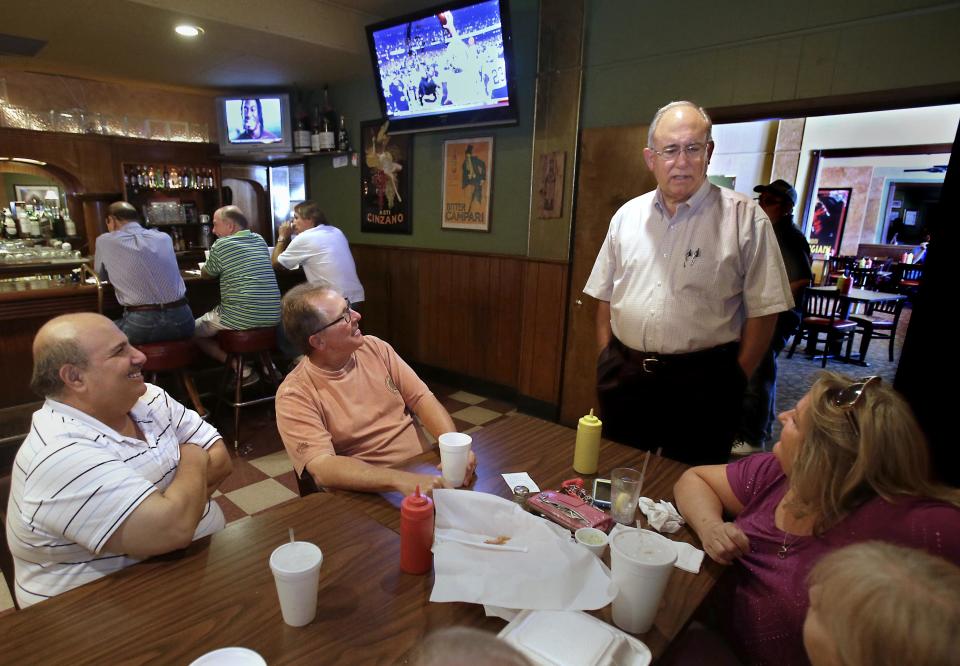 In this photo taken Wednesday, July 17, 2013, Gary Lanfranco, owner of the Cosmopolitan Cafe, standing, talks with lunchtime customers at the downtown Fresno, Calif. eatery that sits in the path of the high-speed rail line. Lanfranco's restaurant is one of hundreds of properties the state needs to buy or seize in the Central Valley to start construction of the first 30 mile segment of the rail line. "I've put the last 45 years of my life" into the restaurant, says Lanfranco, who was dissatisfied with the initial offer he received from the California High- Speed Rail Authority. (AP Photo/Rich Pedroncelli)