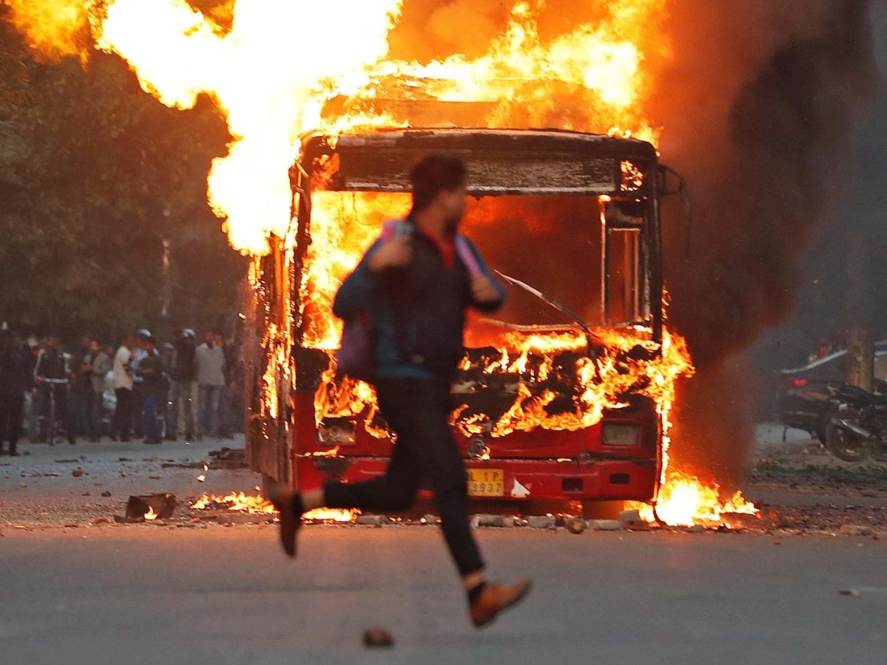 A man runs past a burning bus in New Delhi, India: Adnan Abidi/REUTERS