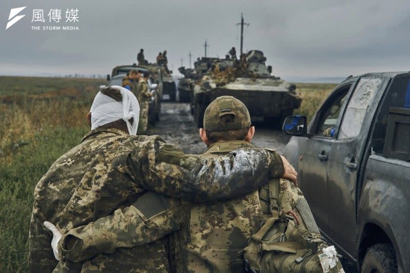 <cite>2022年9月12日，一名烏克蘭士兵在哈爾基夫地區攙扶受傷的戰友。（美聯社）</cite>