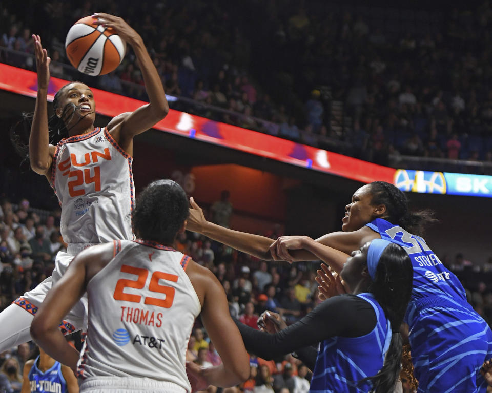 Connecticut Sun forward DeWanna Bonner (24) pulls down the defensive rebound over teammate Alyssa Thomas (25) and Chicago Sky guard Kahleah Copper, front right, and forward Azurá Stevens, back right, during a WNBA basketball game in Uncasville, Conn., Sunday, July 31, 2022. (Sean D. Elliot/The Day via AP)