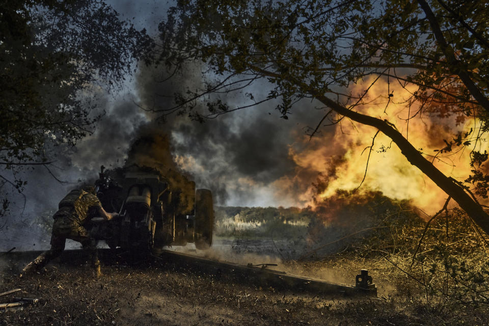 A Ukrainian policeman of special police unit fires a D-30 cannon towards Russian positions at the front line, near Kreminna, Luhansk region, Ukraine, Friday, July 7, 2023. (AP Photo/Libkos)