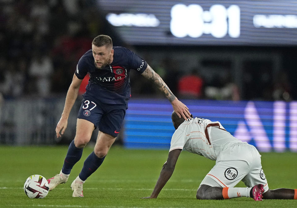 Milan Skriniar, del París Saint-Germain, comete una falta sobre Ibrahima Kone, de Lorient, en el partido de liga disputado el sábado 12 de agosto de 2023 (AP Foto/Michel Euler)