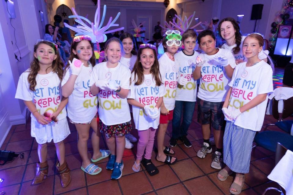 Palm Beach Synagogue hosted a Glow in the Dark Model Seder on Sunday. More than 100 children donned glow-up gear and “Let My People GLOW” T-shirts as part of the event.