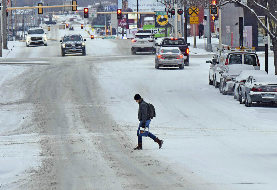 Winter returned to the Bismarck Mandan with snow covering the area slowing commute times for people walking and driving., Thursday, March 21, 2024 in Bismarck, N.D. Parts of Montana, the Dakotas, Minnesota, Illinois and Wisconsin are under winter weather advisories, with snow expected to start falling Thursday in some areas. Minnesota could see a foot of snow over the weekend, and parts of New England could also see 12 to 18 inches (30 to 45 centimeters) in the coming days. (Tom Stromme/The Bismarck Tribune via AP)