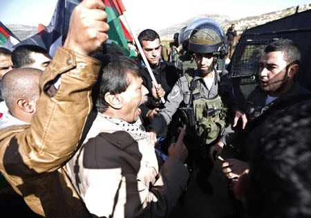 Palestinian minister Ziad Abu Ein (C) argues with Israeli border policemen during a protest near the West Bank city of Ramallah December 10, 2014. REUTERS/Mohamad Torokman