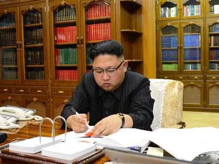 North Korean Leader Kim Jong Un signs the order to carry out the test-fire of inter-continental ballistic rocket Hwasong-14 in this undated photo released by North Korea's Korean Central News Agency (KCNA) in Pyongyang, July, 4 2017. KCNA/via REUTERS