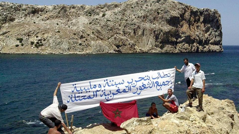 En julio de 2022, manifestantes marroquíes se pararon en la costa de Marruecos frente al islote de Perejil con un cartel que decía: 