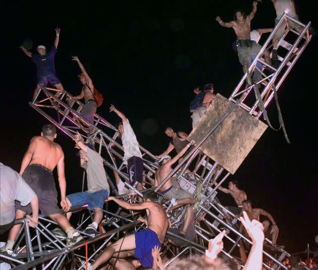 A group of young men climb to the top of a sound tower and knock it down in footage from the music festival shown in 