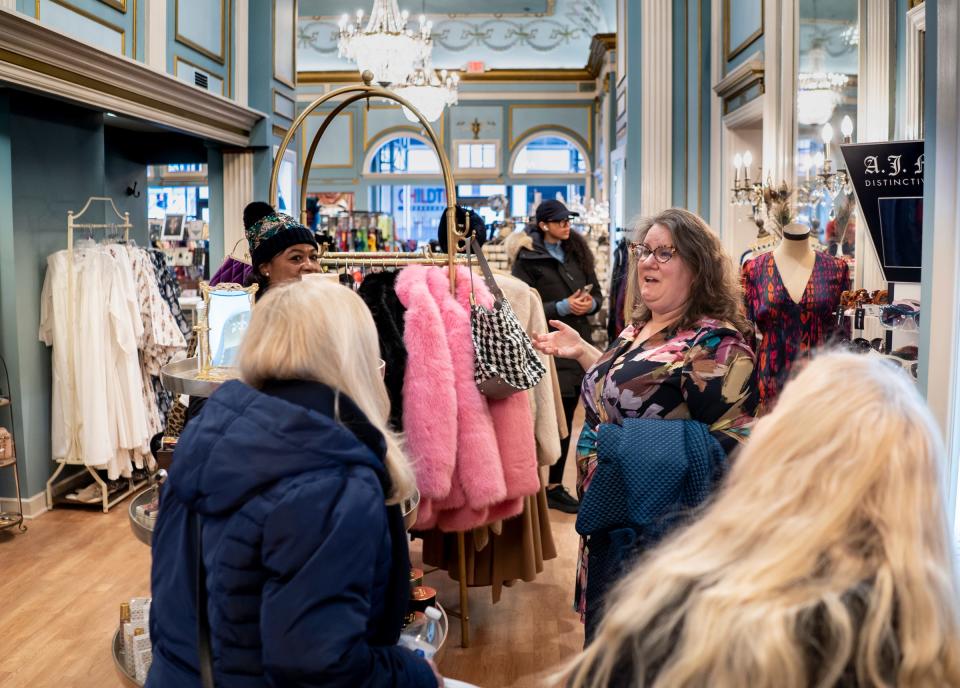 The Peacock Room proprietress Rachel Lutz, right, talks with visitors shopping at her business located in the Fisher Building in Detroit on Wednesday, November 29, 2023.