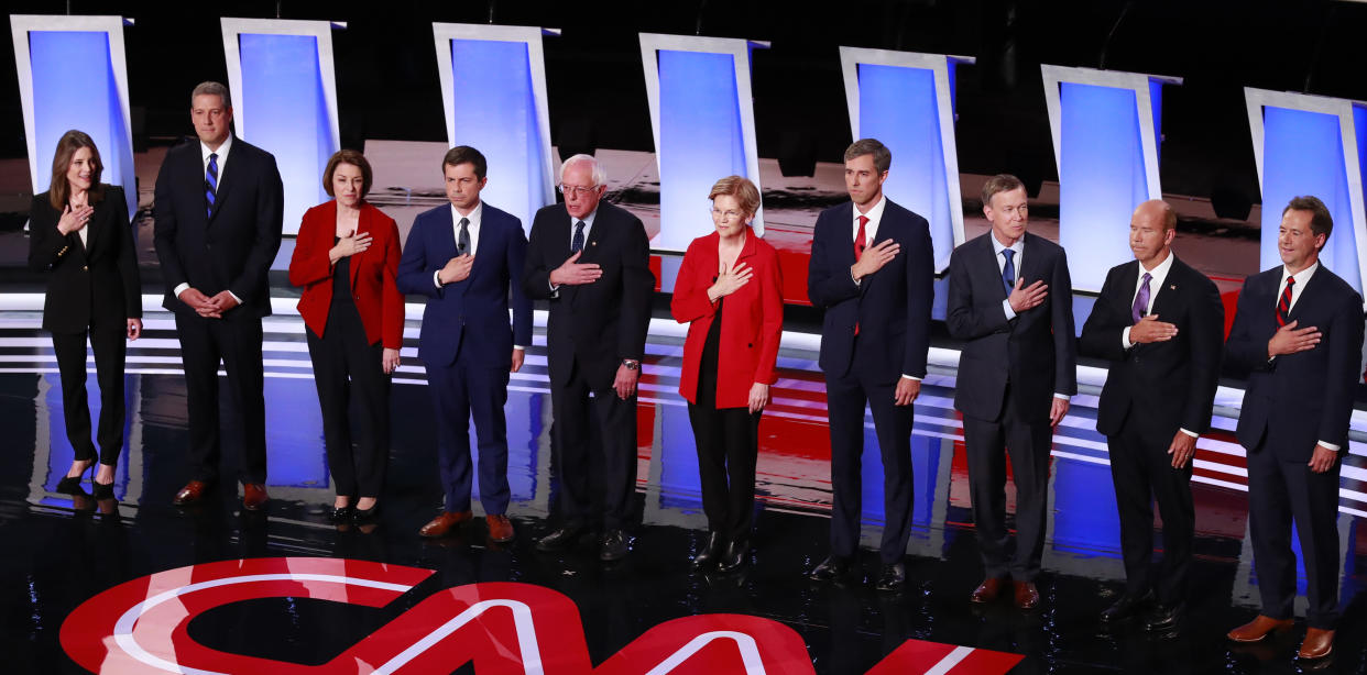 Democratic 2020 U.S. presidential candidates stand for the national anthem (L-R) author Marianne Williamson, U.S., Rep. Tim Ryan, U.S. Senator Amy Klobuchar, South Bend Mayor Pete Buttigieg, U.S. Senator Bernie Sanders, U.S. Senator Elizabeth Warren, former U.S. Rep. Beto O'Rourke, former Colorado Governor John Hickenlooper, former U.S. Rep. John Delaney, Montana Governor Steve Bullock on the first night of the second 2020 Democratic U.S. presidential debate in Detroit, Michigan, July 30, 2019. REUTERS/Lucas Jackson