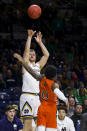 Notre Dame's Rex Pflueger, left, shoots a 3-pointer over Miami's Chris Lykes (0) during the second half of an NCAA college basketball game Sunday, Feb. 23, 2020, in South Bend, Ind. (AP Photo/Robert Franklin)