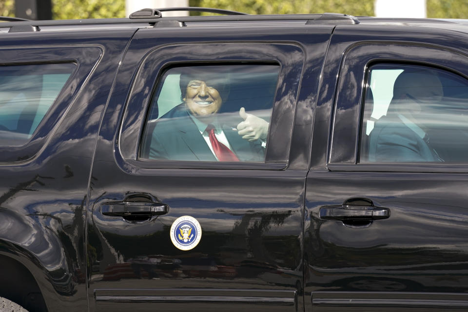 President Donald Trump gestures to supporters en route to his Mar-a-Lago Florida Resort on Wednesday, Jan. 20, 2021, in West Palm Beach, Fla. (AP Photo/Lynne Sladky)
