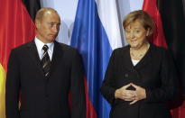 FILE - German Chancellor Angela Merkel, right, and Russian President Vladimir Putin hold a news conference after bilateral talks in Dresden, on Oct. 10, 2006. Merkel has been credited with raising Germany’s profile and influence, helping hold a fractious European Union together, managing a string of crises and being a role model for women in a near-record tenure. Her designated successor, Olaf Scholz, is expected to take office Wednesday, Dec. 8, 2021. (AP Photo/Markus Schreiber, File)