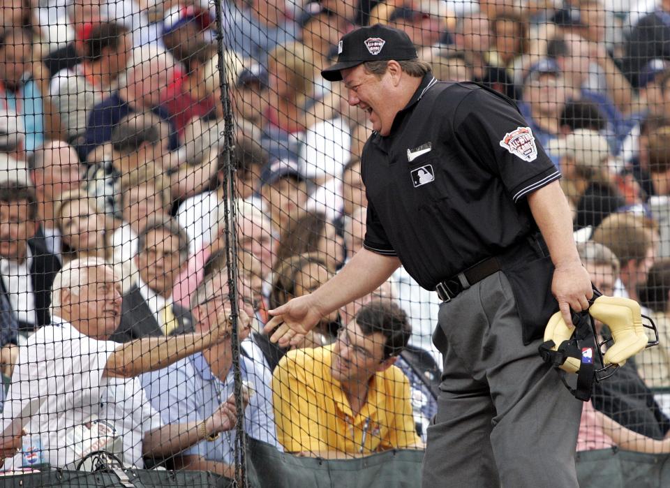 Joe West shakes hands with former Dodgers manager Tommy Lasorda before the start of the All-Star Game in 2005.