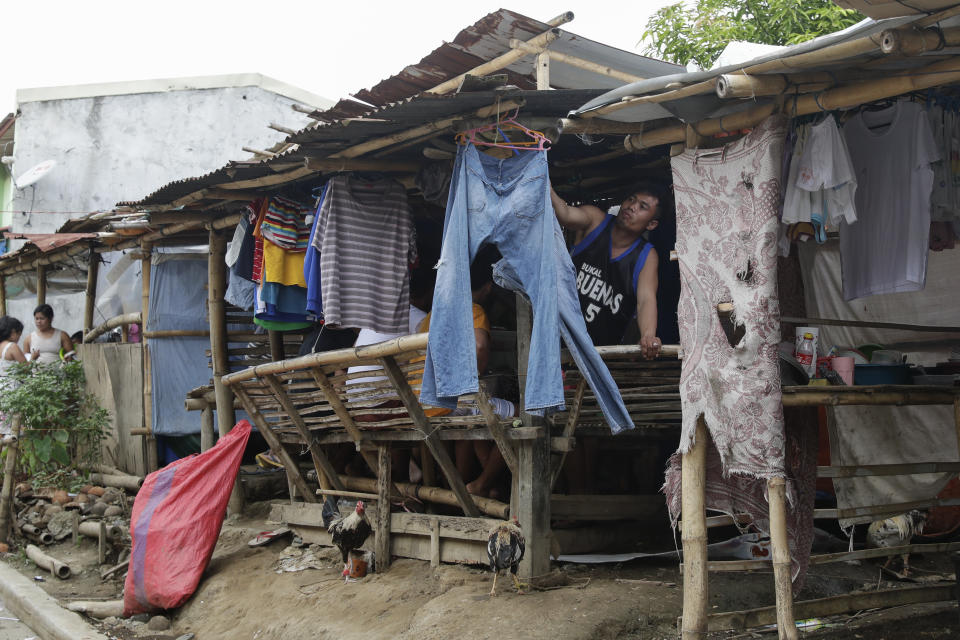 A man who used to live at Taal volcano arranges his laundry at their makeshift tent at a relocation site in Balete, Batangas province, Philippines, on Sunday, Jan. 10, 2021. Some families are still living in tents and have resorted to taking odd jobs to make a living as the government has prevented them from returning back to their homes almost a year after Taal volcano erupted on Jan. 12, 2020. The eruption displaced thousands of villagers living near the area and delivered an early crisis this year for one of the world's most disaster-prone nations a couple of months before the COVID-19 pandemic broke in the country. (AP Photo/Aaron Favila)