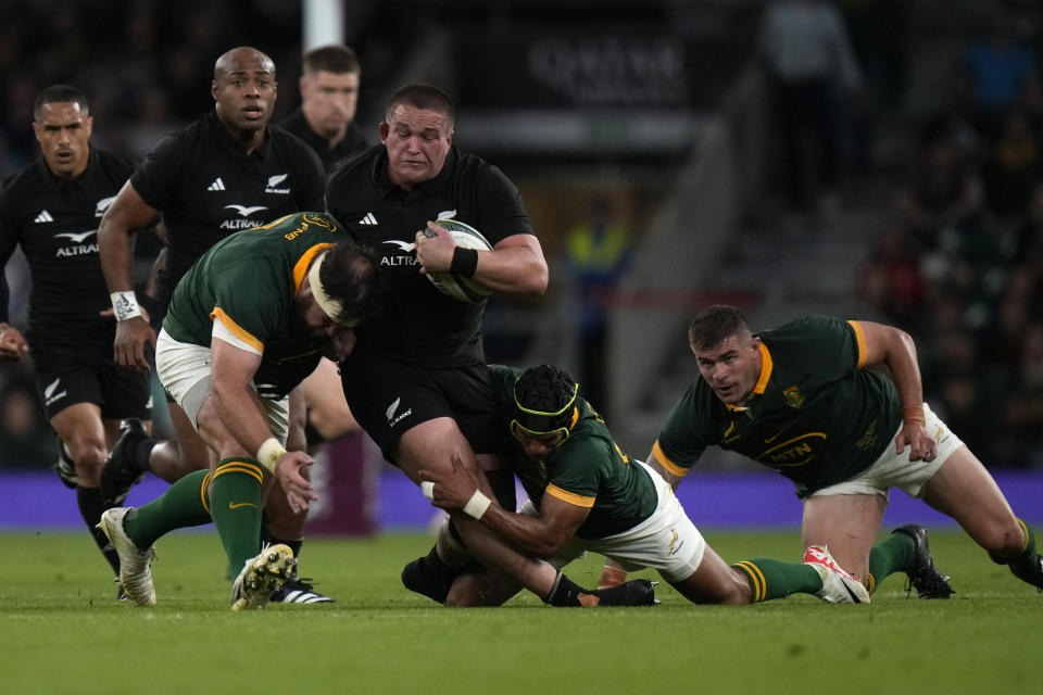 New Zealand's Ethan de Groot, centre, is challenged by South Africa's Kurt-Lee Arendse, bottom, during the rugby union international match between South Africa and New Zealand, at Twickenham stadium in London, Friday, Aug. 25, 2023. (AP Photo/Alastair Grant)