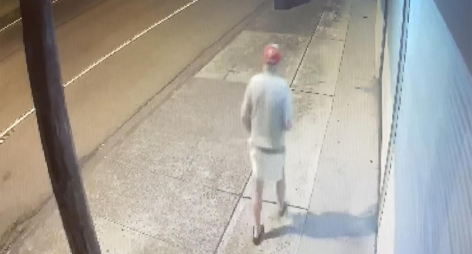 CCTV footage of Bernard Anable's last confirmed sighting, his back is to the camera wearing a red cap, long sleeved grey shirt and white shorts.