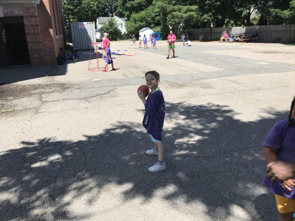 Camp Taunton participant Nolan Green, 5 prepares to throw a football to a playmate outside Hopewell Elementary School.