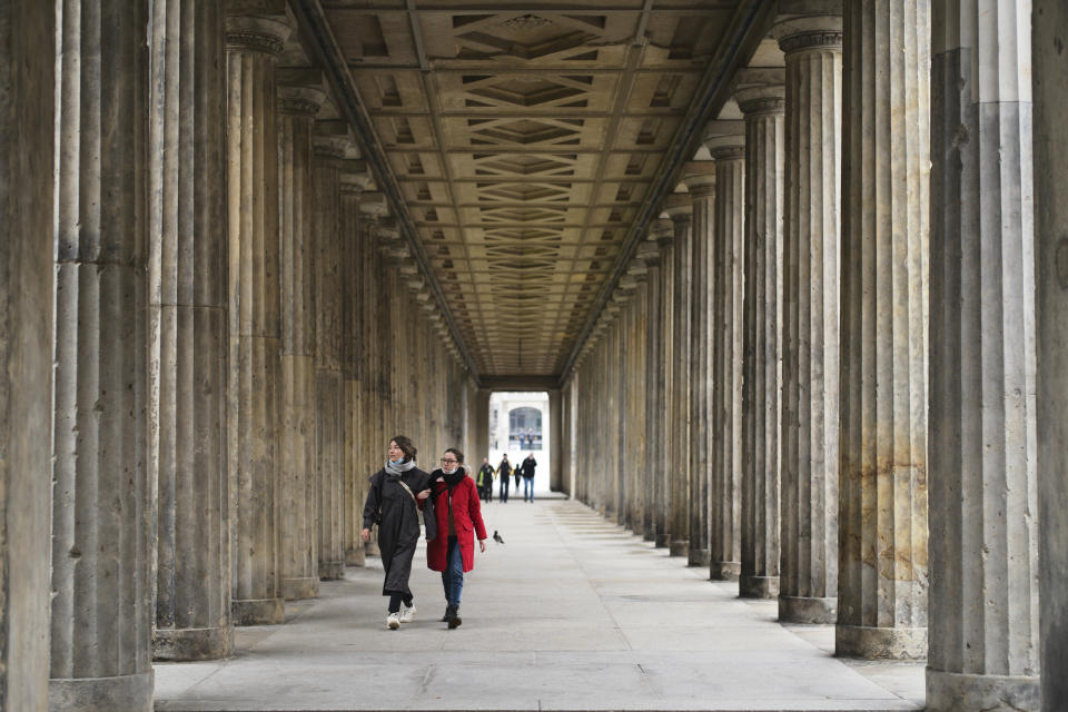 People walk through a colonade in the Museums Island in Berlin, Wednesday, Oct. 21, 2020. A large number of art works and artifacts at some of Berlin's best-known museums were smeared with a liquid by an unknown perpetrator or perpetrators earlier this month, police said Wednesday. The 'numerous' works in several museums at the Museum Island complex, a UNESCO world heritage site in the heart of the German capital that is one of the city's main tourist attractions, were targeted between 10 a.m. and 6 p.m. on Oct. 3, police said. (AP Photo/Markus Schreiber)