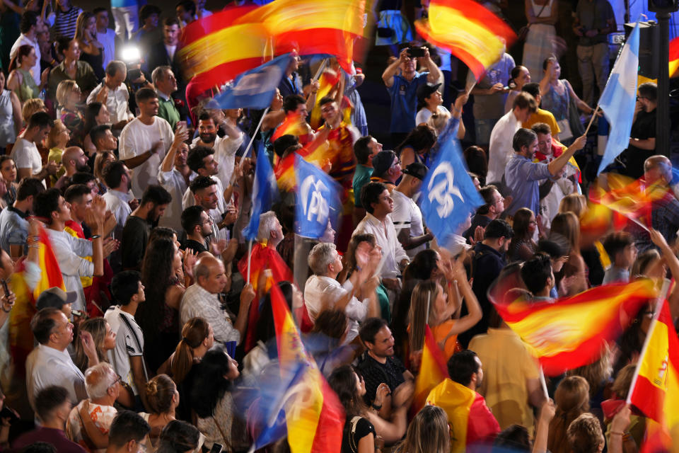 Supporters of Spain's mainstream conservative Popular Party supporters wave flags while waiting for its leader Alberto Feijoo to address them following Spain's general election, in Madrid, Sunday, July 23, 2023. Spain's conservative Popular Party is set to narrowly win the country's national election but without the majority needed to topple the coalition government of Socialist Prime Minister Pedro Sánchez. (AP Photo/Manu Fernandez)