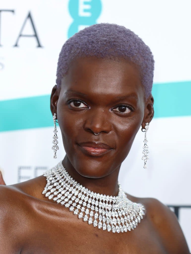 A closeup on Sheila Atim wearing a mult-tiered diamond necklace and drop earrings