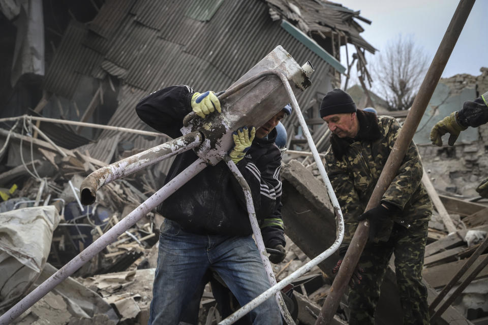 Ukrainian volunteers clear debris at a damaged maternity hospital in Vilniansk, Zaporizhzhia region, Ukraine, Wednesday, Nov. 23, 2022. A Russian rocket struck the maternity wing of a hospital in eastern Ukraine on Wednesday, killing a newborn boy and critically injuring a doctor. The overnight explosion left the small-town hospital a crumbled mess of bricks, scattering medical supplies across the small compound. (AP Photo/Kateryna Klochko)