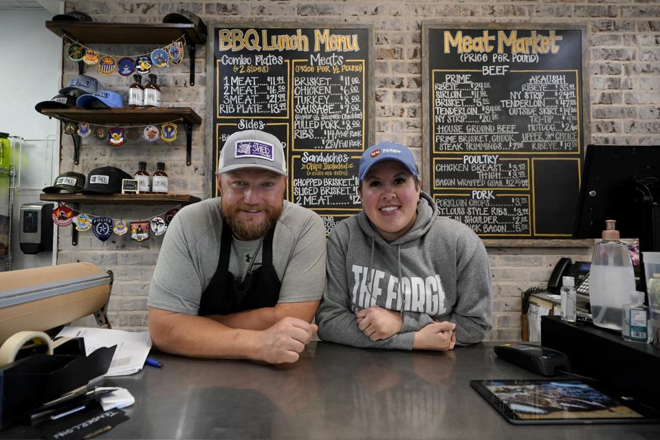 Byron Stephenson and his wife Stacie, owners of the The Shed Market, a barbecue restaurant, pose for a photo at their storefront counter on Wednesday, Dec. 16, 2020, in Abilene, Texas. (AP Photo/Tony Gutierrez)